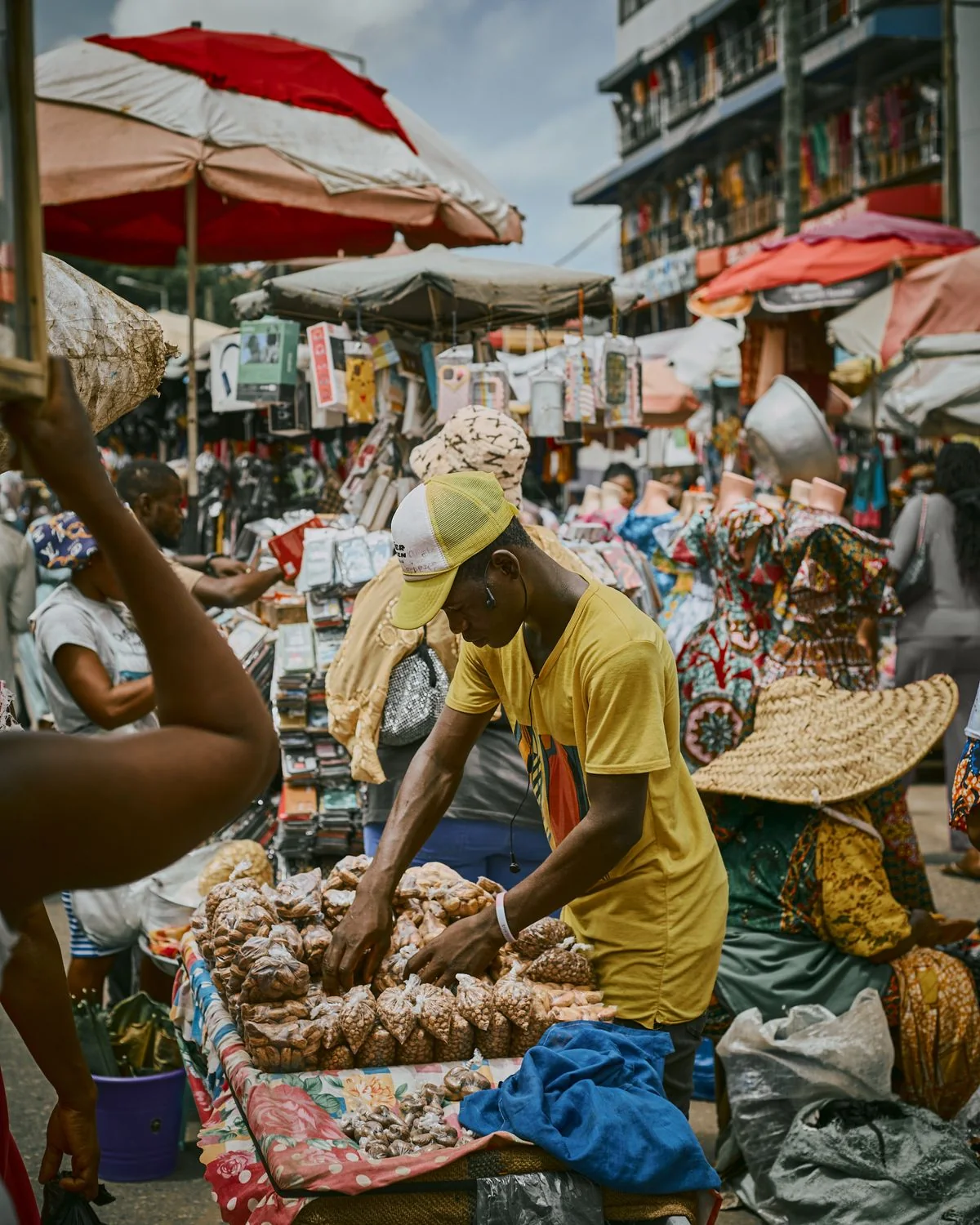 A vendor serves customers at a busy outdoor market.
